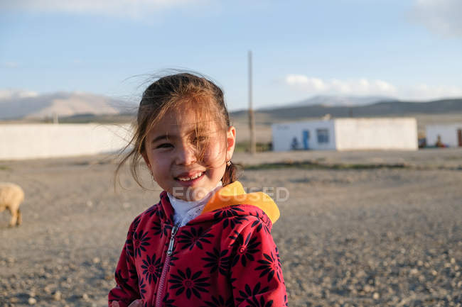 Asiatique fille souriant agitant à la main à la caméra, Tadjikistan — Photo de stock