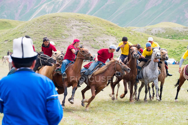 Región OSH, KYRGYZSTAN - 22 de julio de 2017: Nomadgames, men riding on horses, participants in goat polo - foto de stock