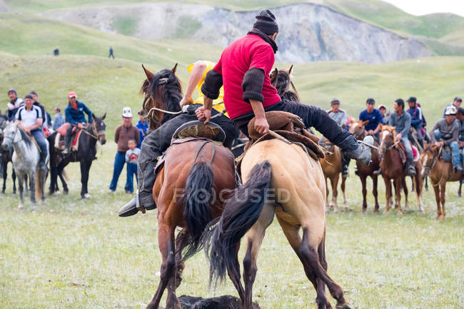 Región OSH, KYRGYZSTAN - 22 de julio de 2017: Nomadgames, los hombres compiten en caballos, los participantes en el polo de cabra - foto de stock