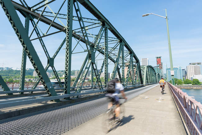 Personas montadas en bicicletas cruzando el puente Hawthorne en Portland, Estados Unidos - foto de stock