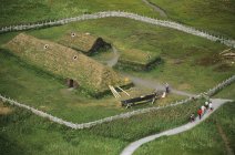 Vista aérea dos turistas que caminham no assentamento histórico viking Lanse aux meadows, Terra Nova, Canadá . — Fotografia de Stock