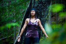Asian woman practicing yoga near Clearwater River, Clearwater, British Columbia, Canada — Stock Photo