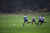 Mädchenfußballmannschaft spielt bei Regen, Sonnenscheinküste, britischem Kolumbien, Kanada — Stockfoto