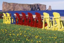 Perce Rock con coloridas sillas de césped, Península Gaspe, Quebec, Canadá . - foto de stock