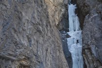 Man climbing rocks in beautiful Ghost River Valley, Alberta, Canadá — Fotografia de Stock