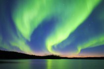 Aurora boreal sobre el lago en el bosque boreal, alrededores de Yellowknife, Territorios del Noroeste, Canadá - foto de stock