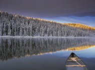 Canoe on Winchell Lake with snow-covered trees in Alberta, Canada. — Stock Photo