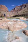 Hiker at Little Colorado River colored by Calcium Carbonate and Copper Sulfate in Grand Canyon, Arizona, United States — Stock Photo