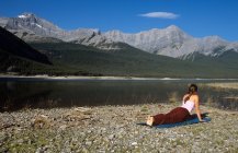 Жінки, які практикують йогу вздовж берега спрей озер, напрямку Kananaskis країни, Альберта, Канада. — стокове фото