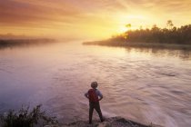 Задній вид чоловічого мандрівного вздовж річки Whiteshell при сходом сонця, Whiteshell Провінційний парк, Манітоба, Канада. — стокове фото