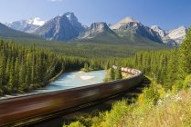 Поезд проходит через кривую Моранта возле озера Луиза в Национальном парке Банф, Альберта, Канада . — стоковое фото