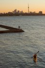 Jeune homme pagayant en kayak sur le lac Ontario à l'entrée de la rivière Humber, Toronto, Ontario, Canada. — Photo de stock