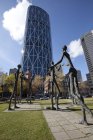 Familia del Hombre esculturas contra edificio moderno en Calgary, Alberta, Canadá . - foto de stock