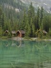 Cabanas de madeira refletindo na água do Lago Ohara, Parque Nacional Yoho, Colúmbia Britânica, Canadá — Fotografia de Stock