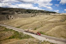 Aerial view over logging truck on road at Chilcotin region of British Columbia in Canada. — Stock Photo