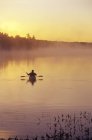Silueta de hombre pesca con mosca de kayak de mar, Lago Muskoka, Ontario, Canadá . - foto de stock