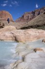 Senderista en Little Colorado River coloreado por carbonato de calcio y sulfato de cobre en el Gran Cañón, Arizona, Estados Unidos - foto de stock