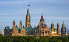 Casas del Parlamento iluminadas por el sol poniente, Ottawa, Ontario, Canadá - foto de stock