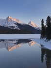 Montagnes Rocheuses reflétant dans l'eau du lac Maligne près de Jasper, Alberta, Canada . — Photo de stock