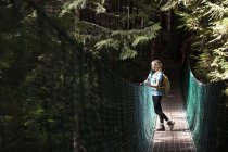 Junge wanderin auf hängebrücke zwischen chinastrand und mystischem strand am weg juan de fuca, vancouver island, kanada. — Stockfoto