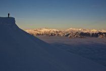 Silueta de esquiador disfrutando del paisaje en las montañas de Kicking Horse Resort backcountry, Golden, British Columbia, Canadá - foto de stock