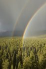 Rainbow and rain on top of mountain in Jasper National Park, Alberta, Canada — Stock Photo