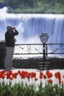 Senior man by American Falls and viewscope, Cascate del Niagara, Ontario, Canada . — Foto stock