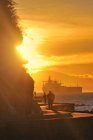 Silhouettes of people strolling on Stanley Park seawall at sunset, Vancouver, British Columbia, Canada — Stock Photo