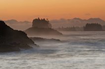 Salida del sol sobre rocas en el mar cerca de Ucluelet, Isla Vancouver, Columbia Británica, Canadá - foto de stock