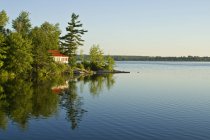 Коттедж с видом на спокойное озеро на севере Кингстона, Онтарио, Канада — стоковое фото