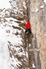 Un jeune homme grimpe un mélange de glace et de roche alors qu'il grimpe sur la glace dans le parc national Banff près de Banff, Alberta, Canada. — Photo de stock