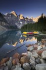 Rocky coast of Moraine Lake with canoes, Banff National Park, Alberta, Canada — Stock Photo