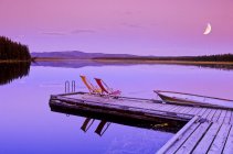 Dock and chairs on Spout Lake in front of Ten-ee-ah Lodge in Cariboo region of British Columbia, Canada. — Stock Photo