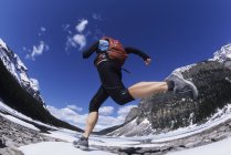 Low angle view of woman running in spring near shore of Moraine Lake in Lake Louise, Banff National Park, Alberta, Canada. — Stock Photo