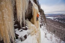 Uomo che scala il ghiaccio ingiallito ripido vicino a Saint Raymond, Quebec, Canada — Foto stock