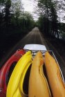 Vista de ángulo alto de la furgoneta en movimiento llena de kayaks de aguas bravas en la carretera en las montañas Laurentian, Quebec, Canadá . - foto de stock