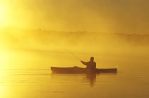 Silhouette de l'homme pêche à la mouche depuis le kayak de mer, lac Muskoka, Ontario, Canada . — Photo de stock