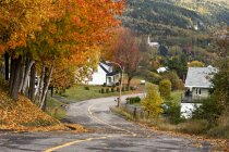Camino rural que desciende a la aldea, Saint-Irenee, Quebec, Canadá - foto de stock