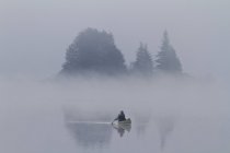 Man paddling solo canoa em Oxtongue Lake, Muskoka, Ontário . — Fotografia de Stock