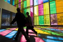 Gli uomini d'affari in silhouette dalle pareti di vetro colorato del centro congressi di Montreal, Montreal, Quebec, Canada . — Foto stock