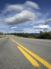 Autostrada sotto le nuvole nel cielo blu a Bighorn Wildland, Alberta, Canada — Foto stock