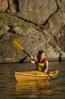 Giovane donna in kayak da mare attraverso Gull Narrows vicino Gravenhurst, Muskoka, Ontario, Canada . — Foto stock
