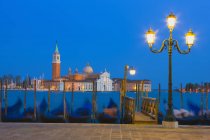 Gondole con chiesa di San Giorgio Maggiore in lontananza di notte, Venezia, Italia — Foto stock