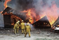 Bomberos rociando edificio en llamas, Columbia Británica, Canadá . - foto de stock