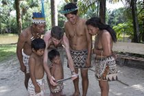 Des villageois autochtones de Bora regardent une tablette numérique au village de Kapitari près de Manacamiri, fleuve Amazone, Pérou — Photo de stock