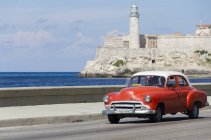 Voiture américaine vintage longeant Malecon avec vue pittoresque sur la forteresse du château de Morro, baie de La Havane, La Havane, Cuba — Photo de stock