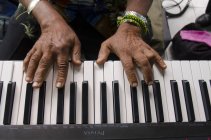 Обрезанный вид женских рук и фортепианной клавиатуры — стоковое фото