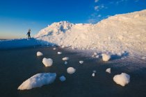 Ein Mann mit Schneeschuhen blickt über angeschwemmte Eisberge am Lake Winnipeg, Manitoba, Kanada — Stockfoto