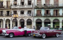 Automóviles clásicos americanos exhibidos por fachada de edificio antiguo de La Habana, Cuba - foto de stock