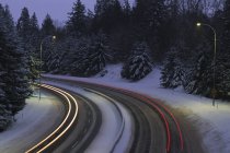 Tráfico de autopistas por la noche con exposición al tiempo con senderos ligeros, British Columbia, Canadá . - foto de stock